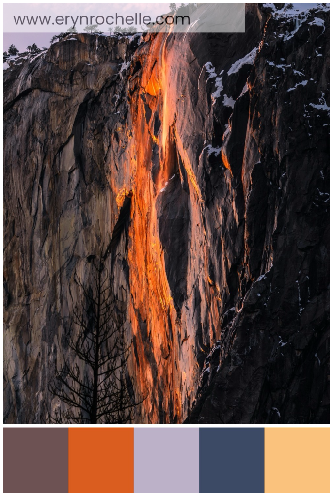 Landscape photography of a gray cliff, featuring a color palette of muted mauve, burnt orange, lavender gray, slate blue, and sunlit sand tones.